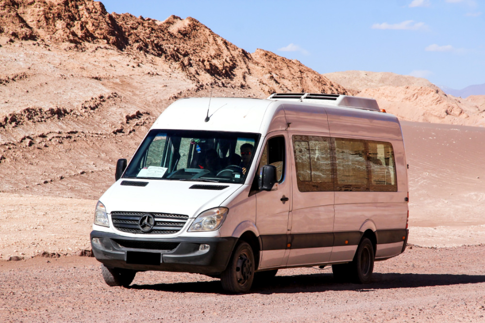 Beste bestelwagens voor koeriers en bezorgers in Dubai Moderne minibus Mercedes-Benz Sprinter op de grindweg