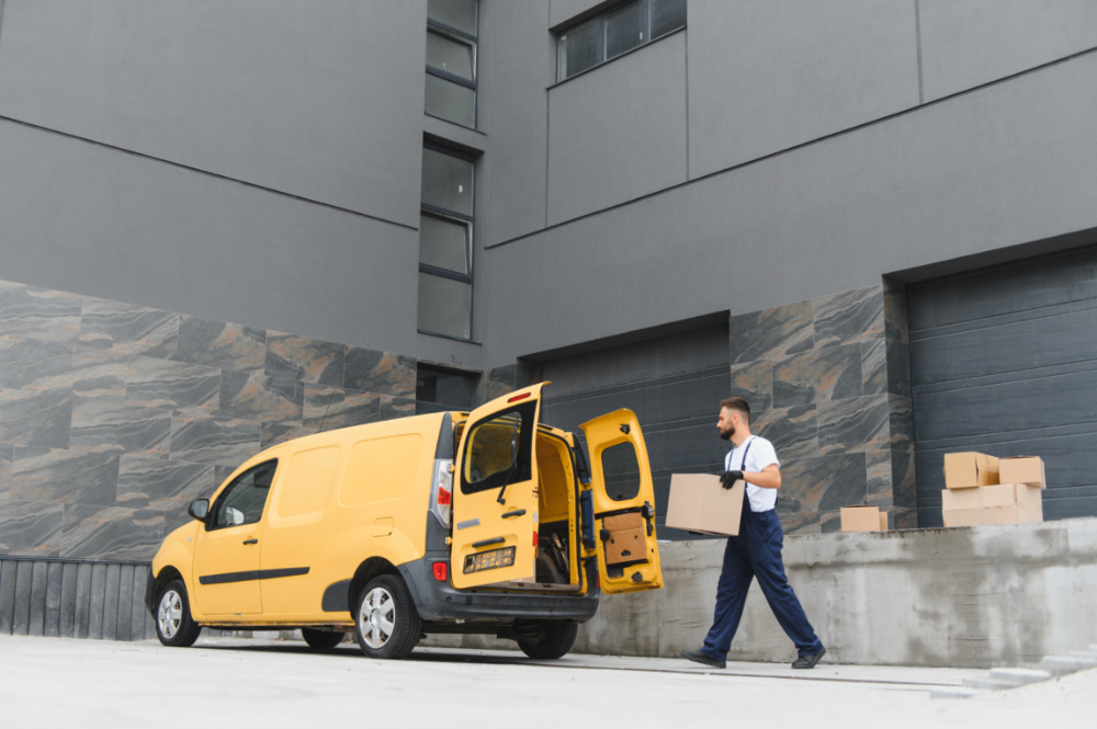 estafeta com luvas e uma caixa de cartão